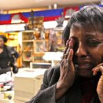 Femme en détresse au téléphone, illustrant le désespoir social et économique lié à la crise en Haïti.