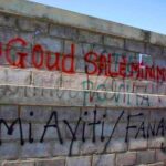 Ouvrier écrivant un message sur un mur lors de la grève à la CODEVI à Ouanaminthe