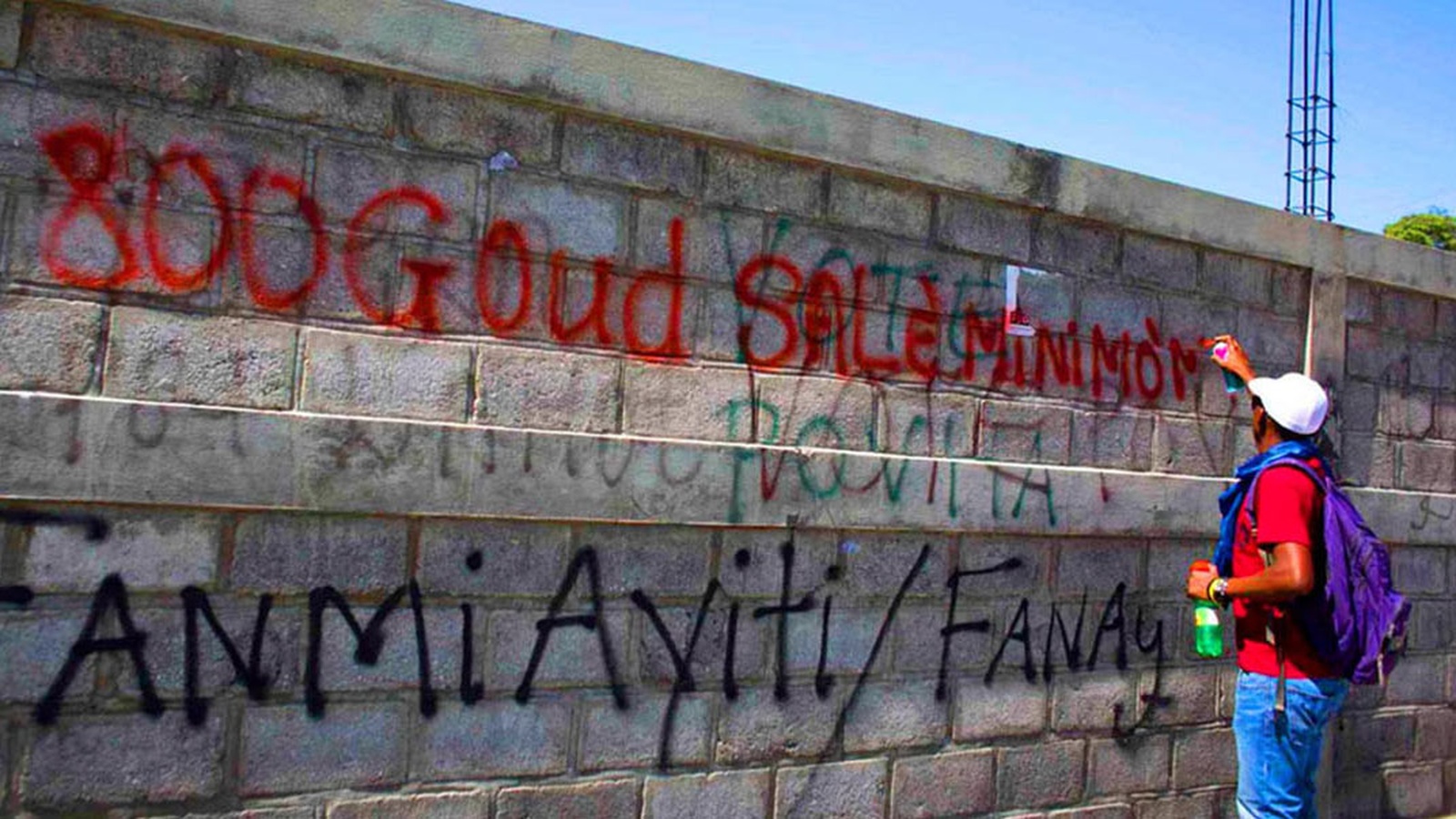 Ouvrier écrivant un message sur un mur lors de la grève à la CODEVI à Ouanaminthe