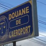 Panneau de la douane de l’aéroport Toussaint Louverture en Haïti, illustrant une protestation des agents douaniers.