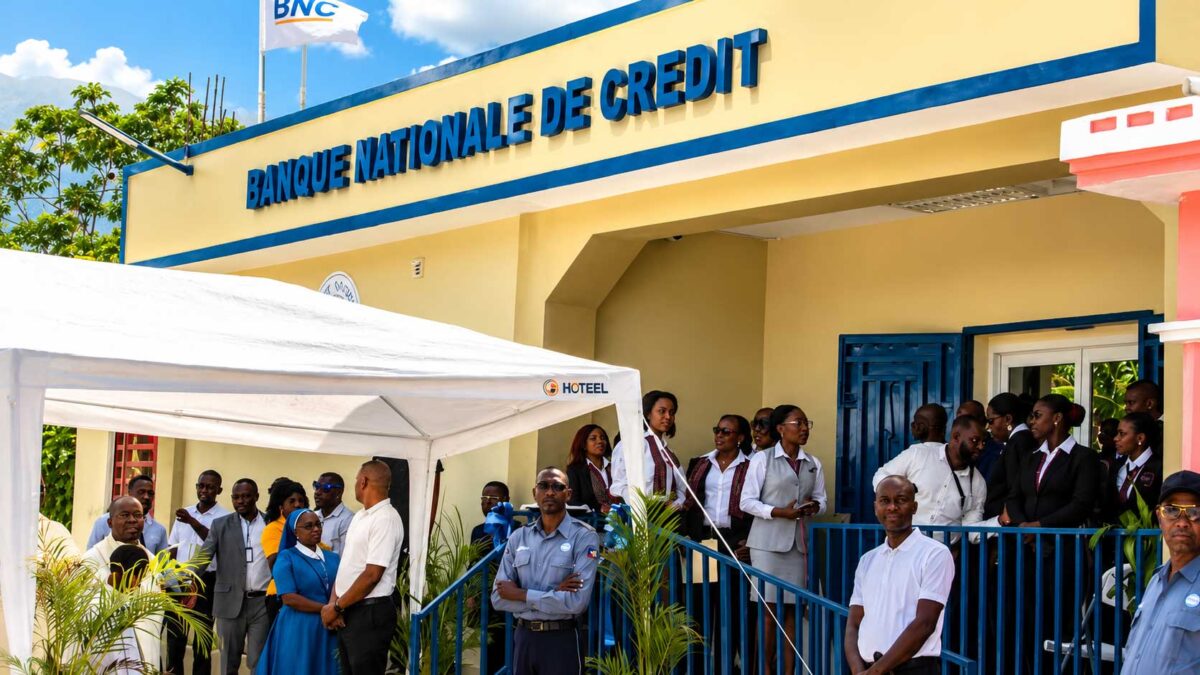Ouverture de la nouvelle succursale de la Banque Nationale de Crédit aux Côteaux, avec des employés, des invités et des membres de la communauté réunis devant l’agence.