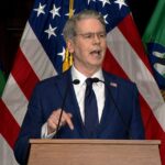 Un responsable américain s’exprime devant des drapeaux des États-Unis et du département du Trésor lors d’une annonce liée aux sanctions contre l’Iran.
