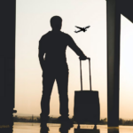 Silhouette d’un voyageur avec une valise dans un aéroport, devant un avion en vol, illustrant un possible retour en Haïti après la fin du TPS.