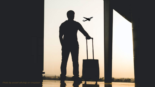 Silhouette d’un voyageur avec une valise dans un aéroport, devant un avion en vol, illustrant un possible retour en Haïti après la fin du TPS.