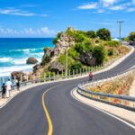 Route côtière en Haïti longeant la mer, illustrant les enjeux d’infrastructures et de développement économique.