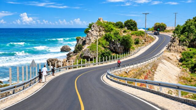 Route côtière en Haïti longeant la mer, illustrant les enjeux d’infrastructures et de développement économique.