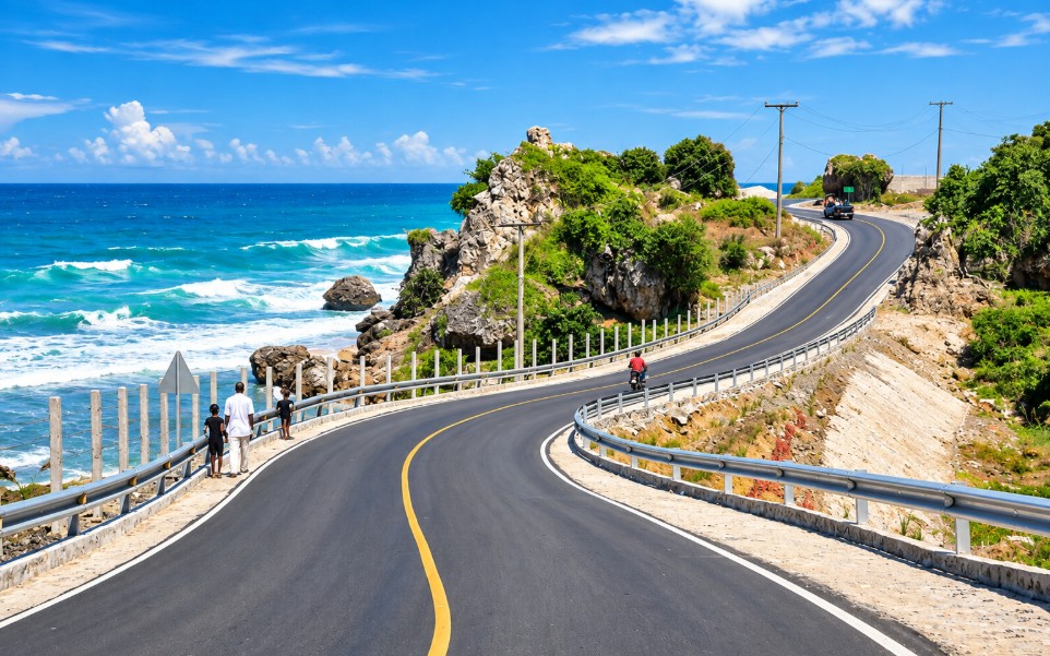 Route côtière en Haïti longeant la mer, illustrant les enjeux d’infrastructures et de développement économique.
