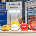 Stand de la Caribbean Bottling Company lors de la Semaine de l’Industrie 2026 en Haïti, présentant des produits et informations sur la qualité et la production.